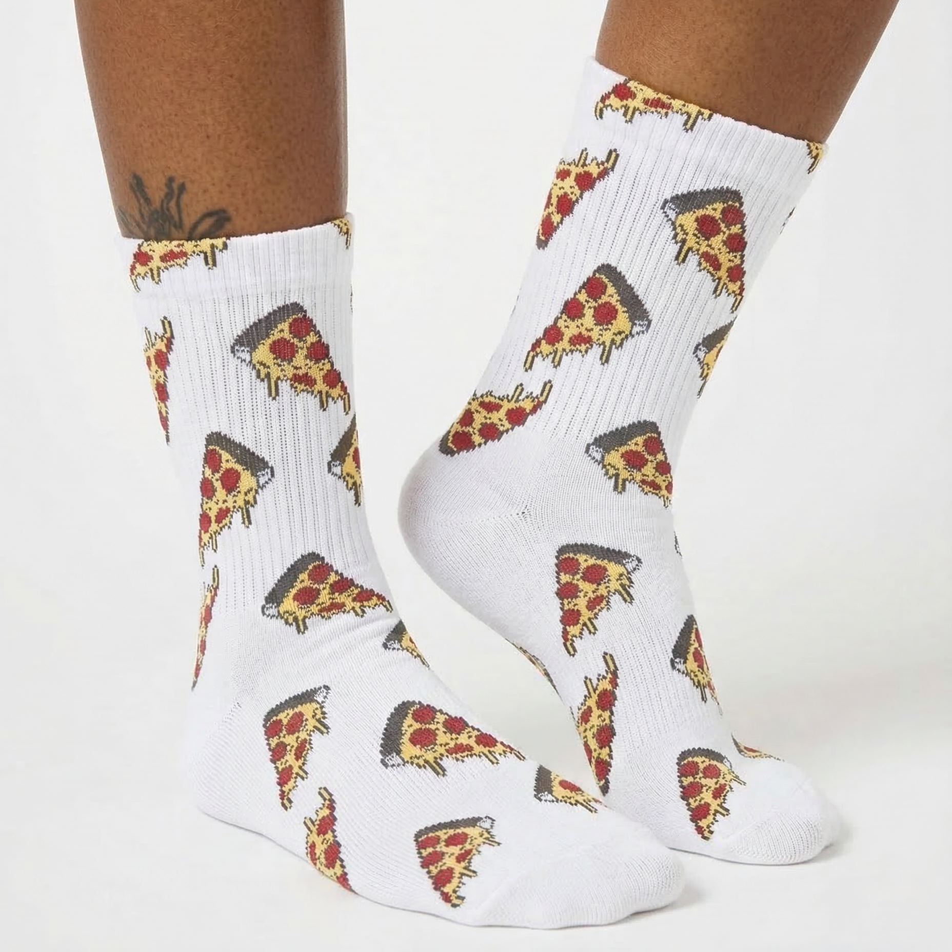 White crew socks with an all-over pizza slice print, shown on a model's feet against a clean white background.