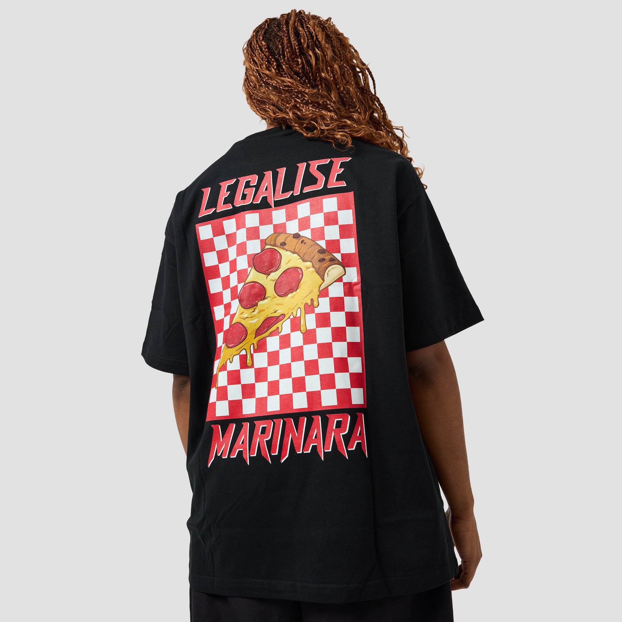 A person shown from the back wearing a black oversized T-shirt with a large red, white, yellow, and brown pizza graphic and the words 'LEGALISE' and 'MARINARA' on the back, against a light gray studio background.