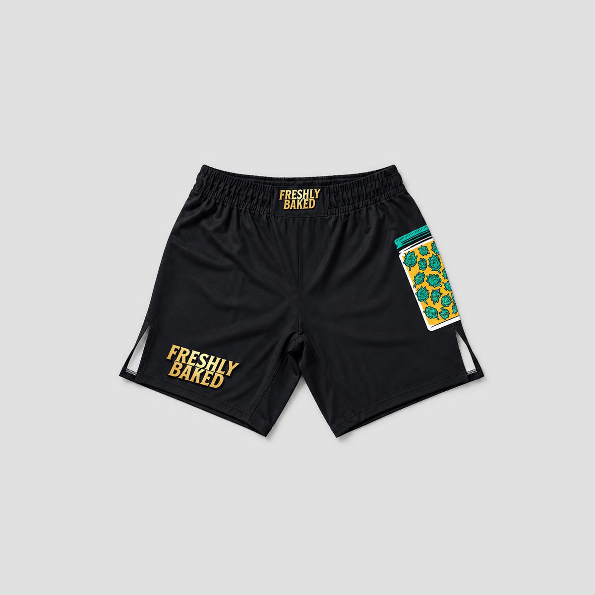 Black athletic shorts with 'FRESHLY BAKED' printed in yellow on the left leg and waistband, featuring a colorful patterned pocket on the right leg, shown on a light gray background.