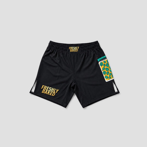 Black athletic shorts with 'FRESHLY BAKED' printed in yellow on the left leg and waistband, featuring a colorful patterned pocket on the right leg, shown on a light gray background.