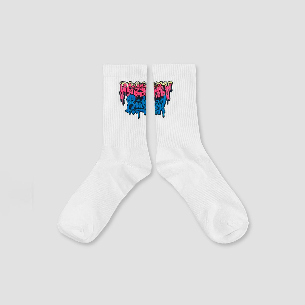 A pair of white crew socks with a colorful graffiti-style graphic near the cuff, displayed against a solid light gray background.