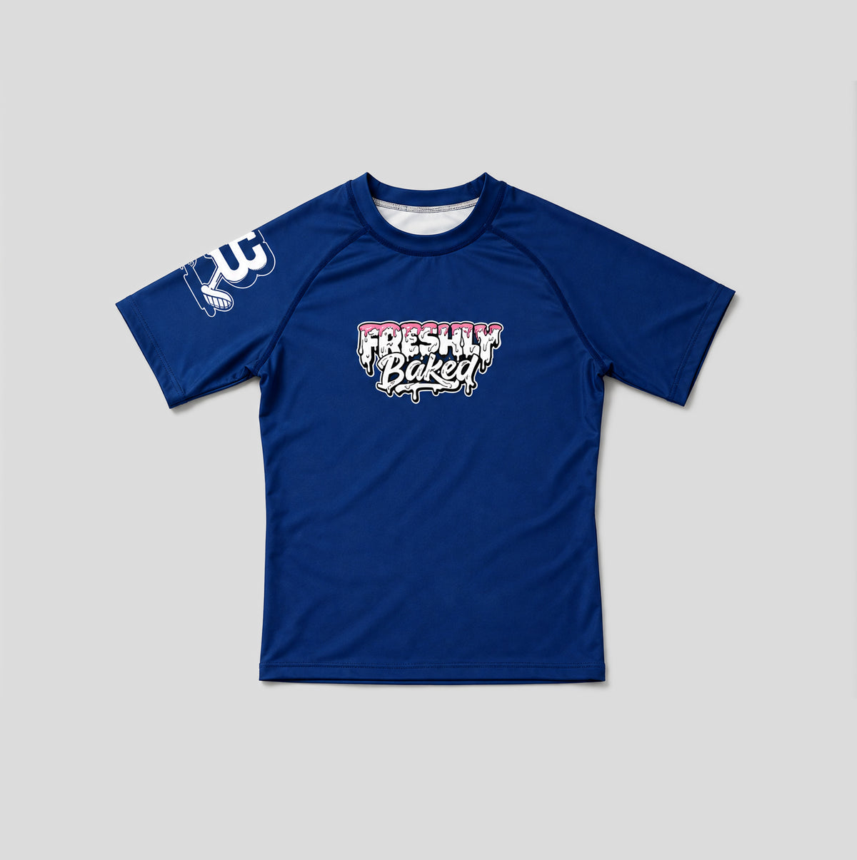A royal blue short-sleeve athletic t-shirt with a 'Freshly Baked' graphic on the chest and a white graphic on the right sleeve, displayed flat against a light gray background.