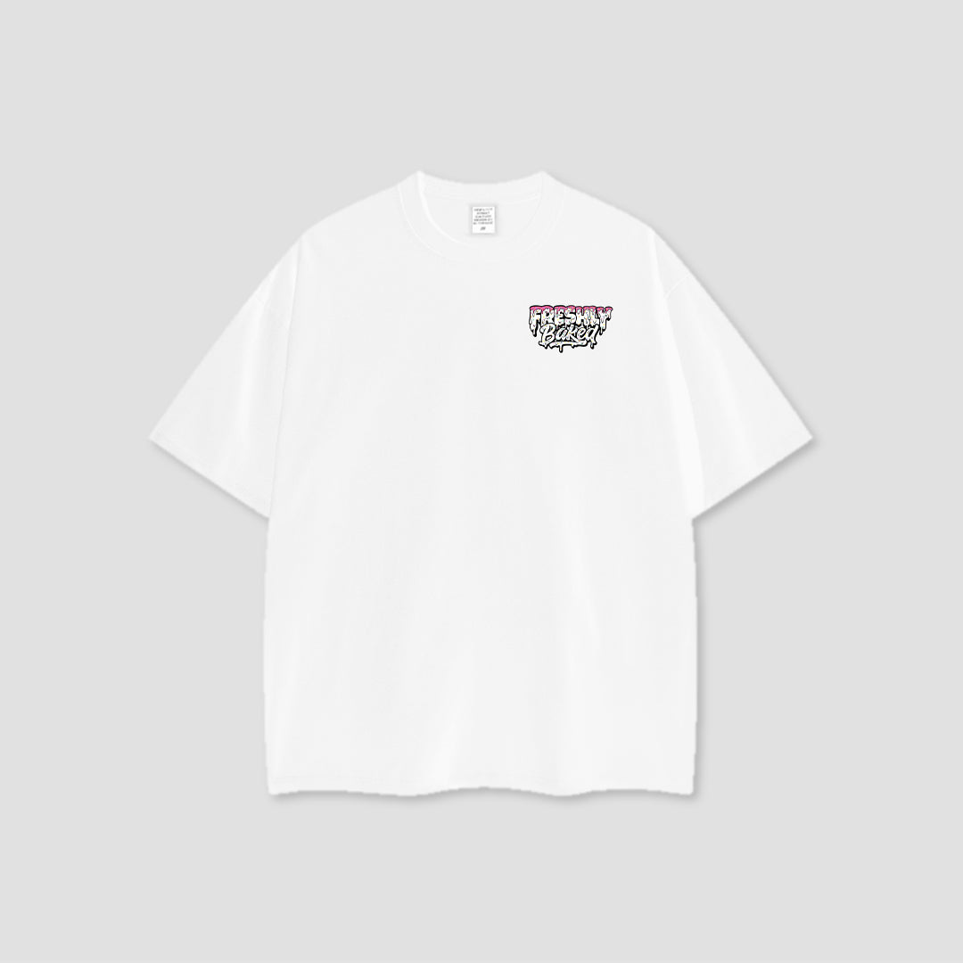 A white short-sleeve crewneck t-shirt with a small graphic on the left chest reading 'Freshly Baked' in a graffiti-style font, displayed on a neutral light gray background.