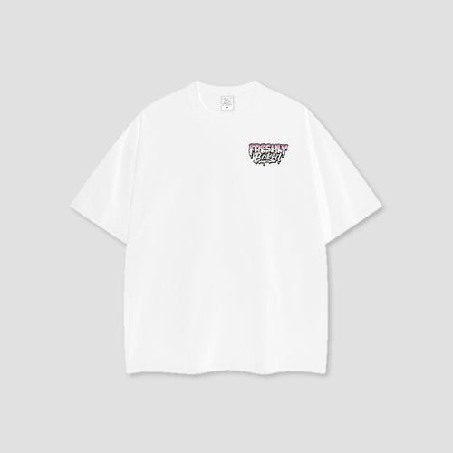 A white short-sleeve crewneck t-shirt with a small graphic on the left chest reading 'Freshly Baked' in a graffiti-style font, displayed on a neutral light gray background.