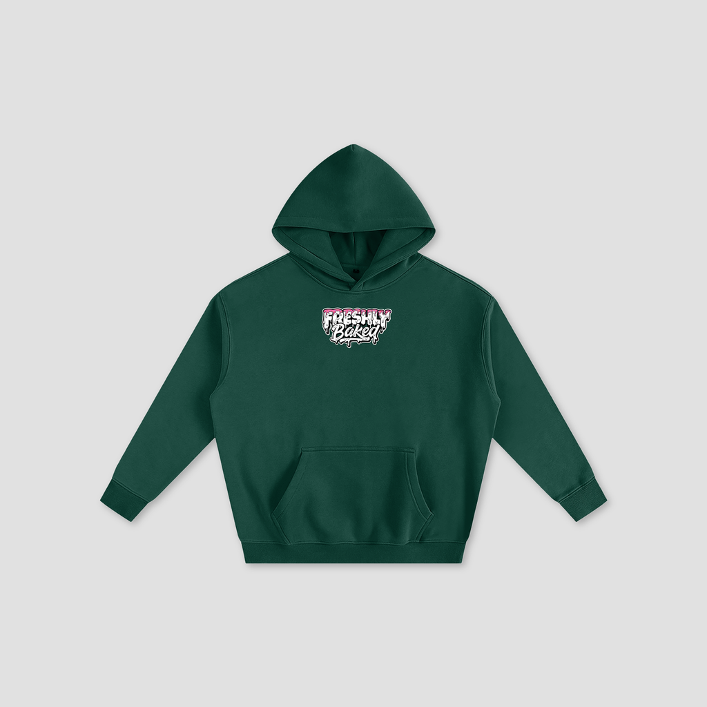 A dark green pullover hoodie with a small graphic on the chest reading 'Freshly Baked' in white, pink, and black, displayed on a light gray background.