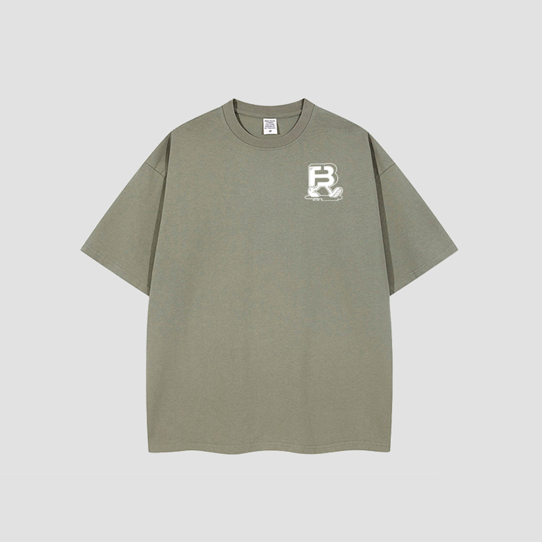 An oversized short-sleeve t-shirt in a muted sage green color, featuring a white graphic logo on the left chest, displayed against a neutral light gray background.