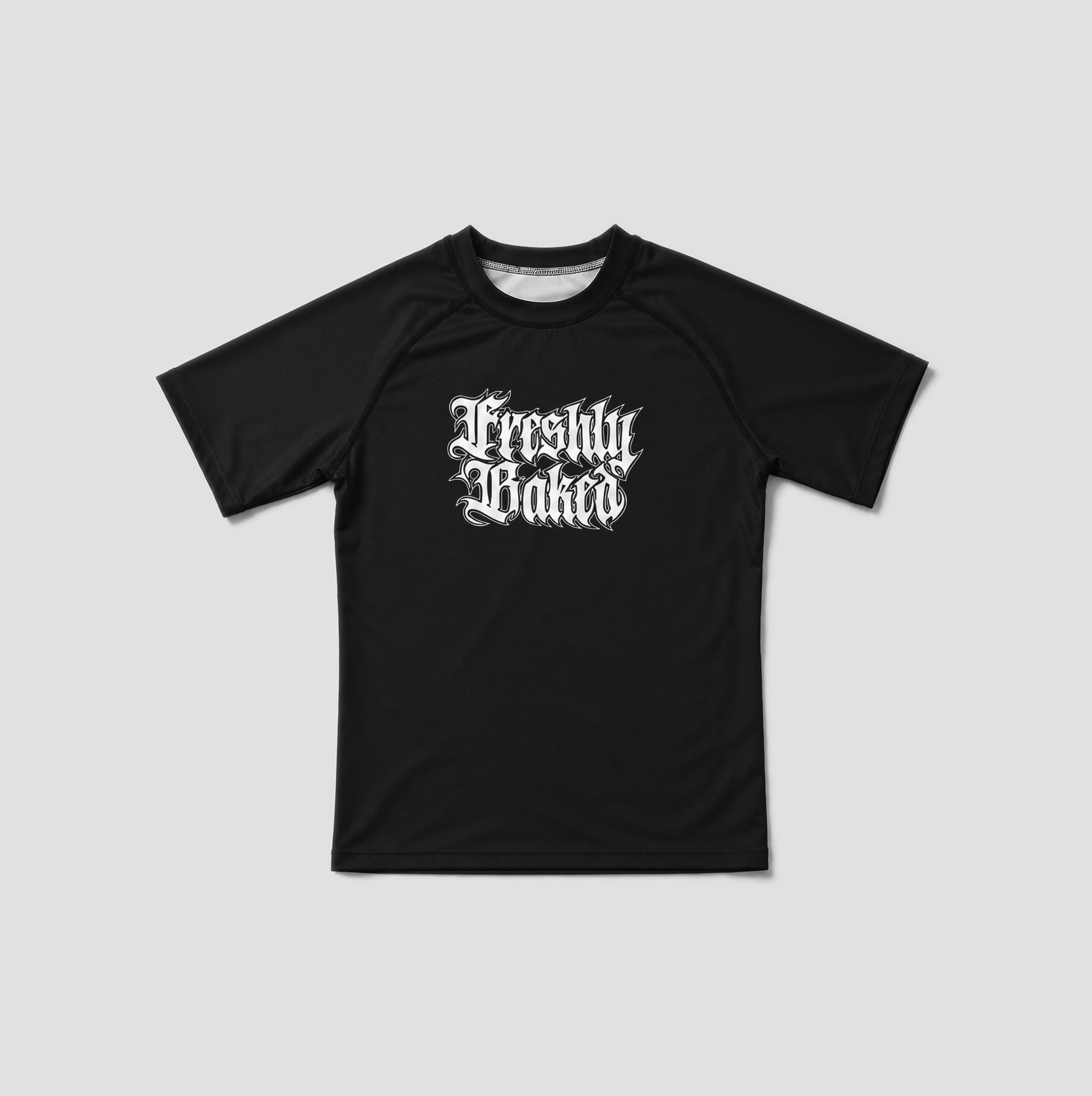 A black short-sleeve athletic t-shirt with a white gothic-style 'Freshly Baked' graphic printed on the chest, displayed flat against a light gray background.