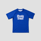 A royal blue short-sleeve athletic t-shirt with 'Freshly Baked' printed in a white gothic font on the chest, displayed against a neutral light gray background.