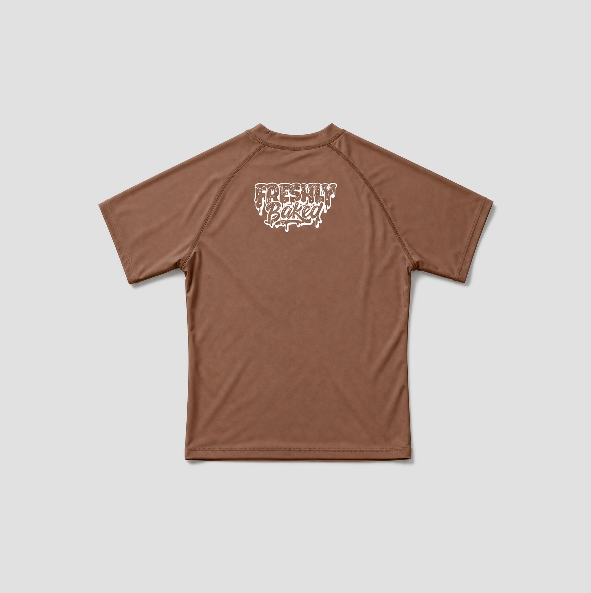 A brown short-sleeve athletic t-shirt with a white 'Freshly Baked' graphic printed on the upper chest, displayed flat against a light gray background.