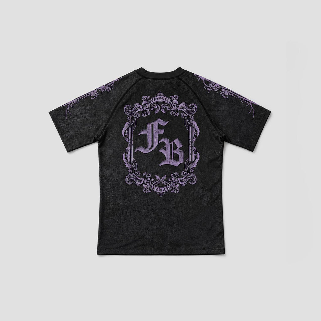 A black short-sleeve t-shirt with a distressed texture, featuring a large purple gothic-style monogram 'FB' inside an ornate frame on the back, with purple decorative details on the shoulders, shown against a light gray background.