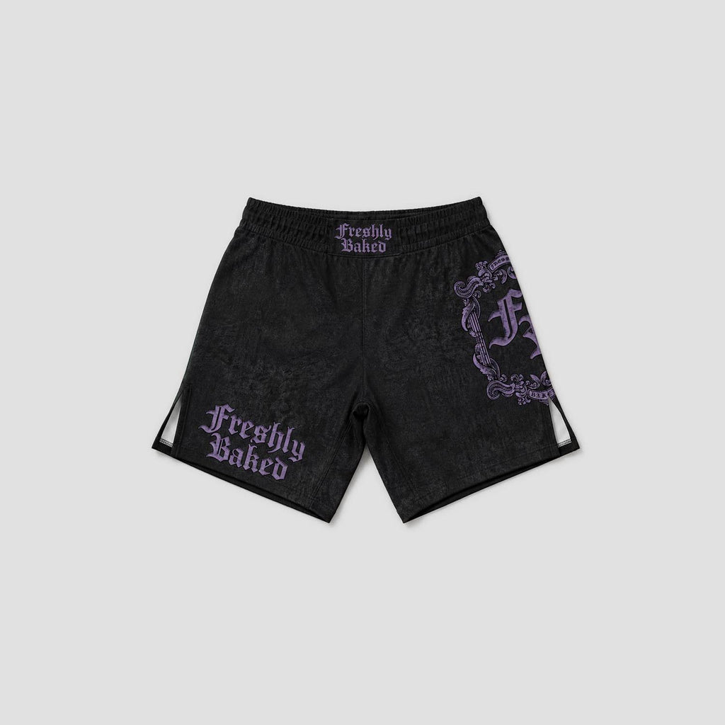 Black athletic shorts with a subtle tonal pattern, featuring purple gothic 'Freshly Baked' text on the left leg and a large matching purple graphic on the right leg, shown against a light gray background.