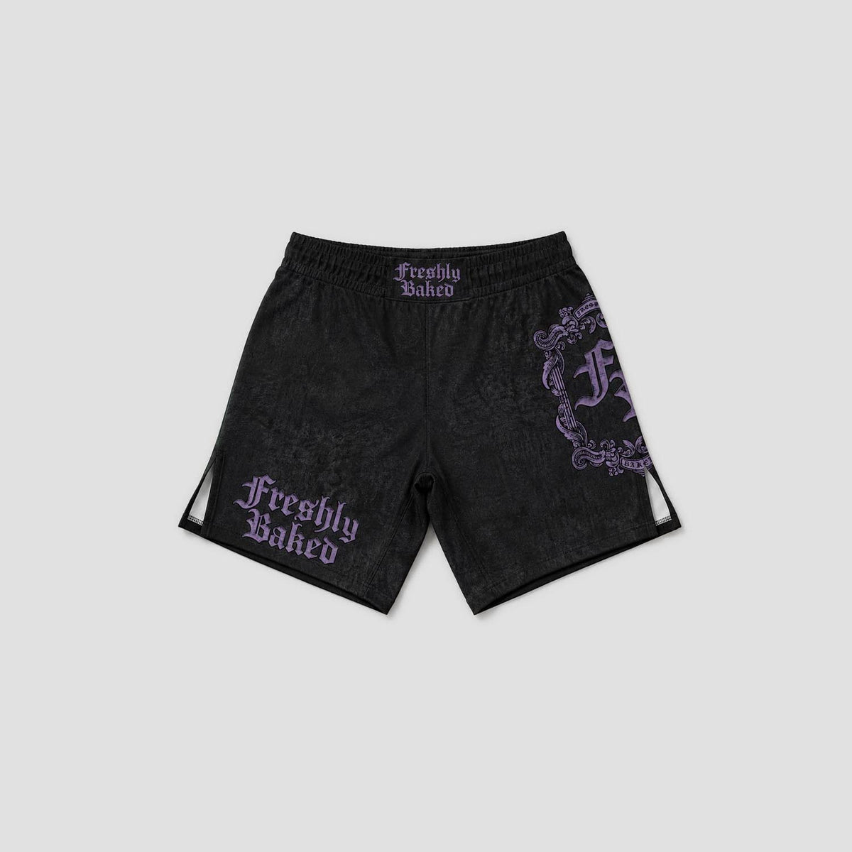 Black athletic shorts with a subtle tonal pattern, featuring purple gothic 'Freshly Baked' text on the left leg and a large matching purple graphic on the right leg, shown against a light gray background.