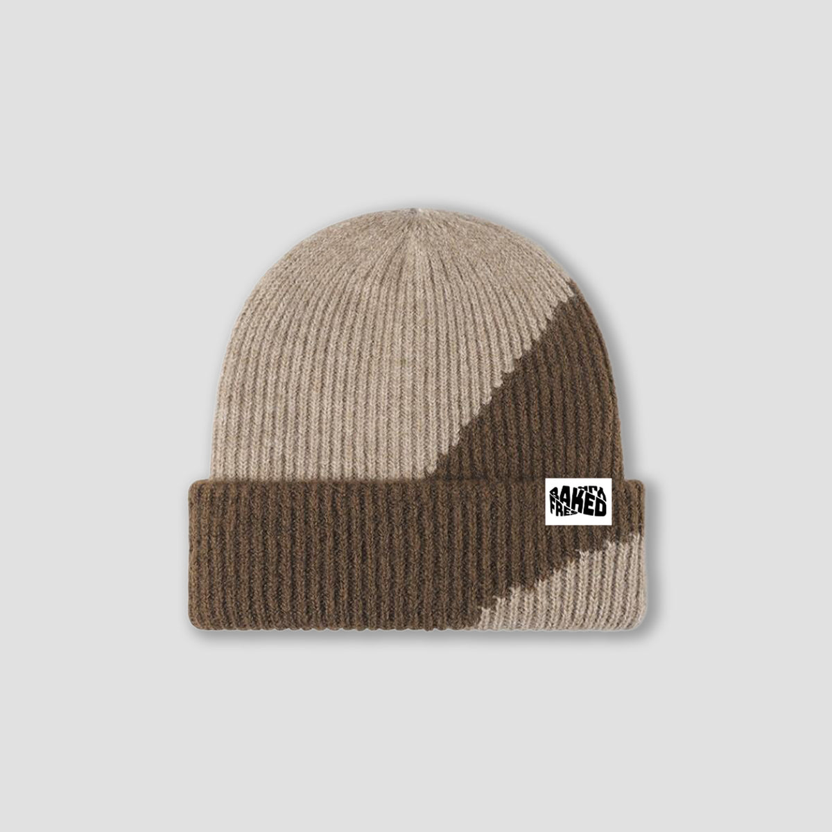 A ribbed knit beanie hat in beige and brown with a small white square patch on the cuff that reads 'FRESHLY BAKED'. The hat is photographed flat against a light gray background.