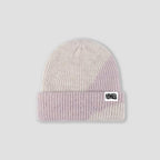 A ribbed knit beanie hat in a soft pastel gradient of cream, light pink, and lavender, featuring a white brand patch on the front cuff that reads FRESHLY BAKED