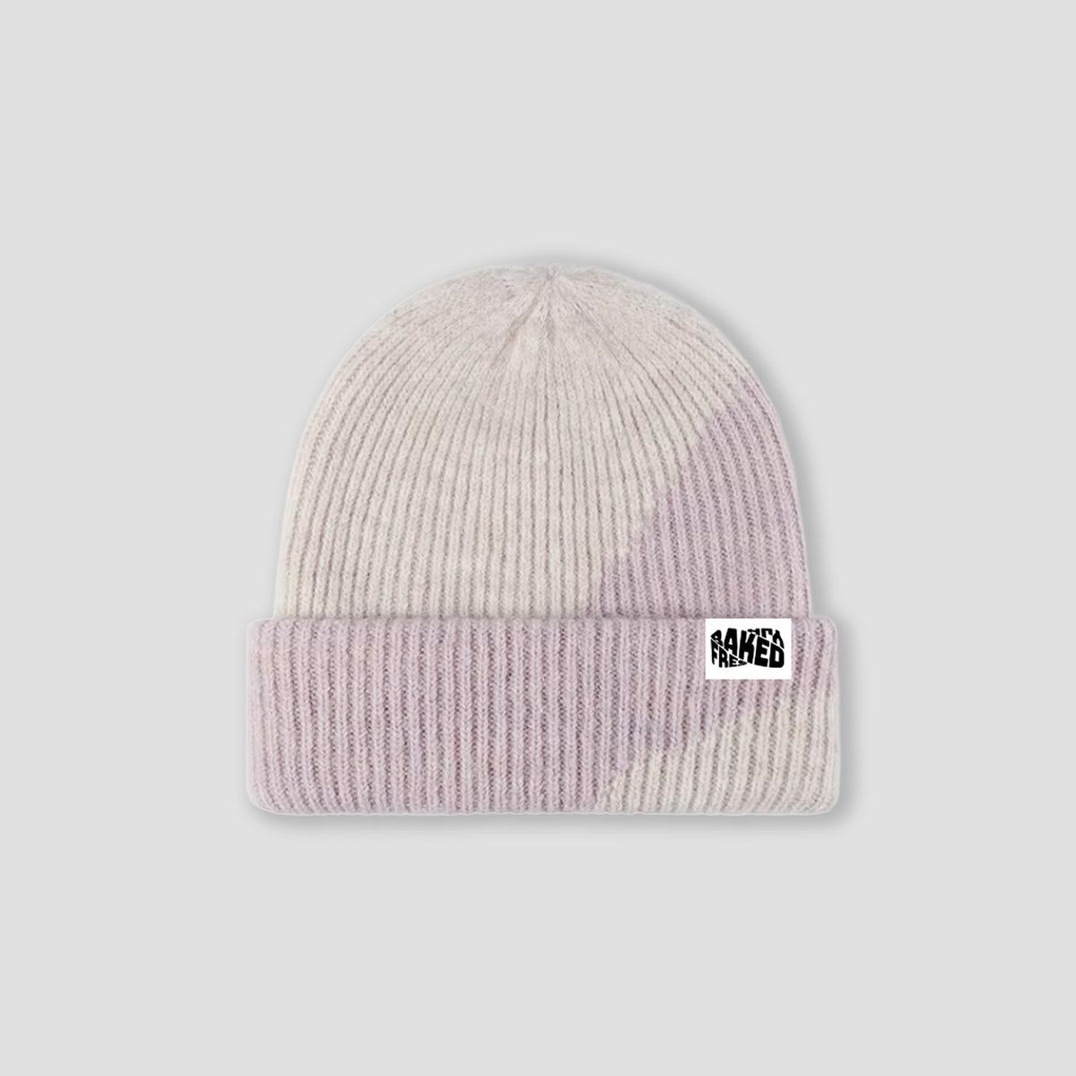 A ribbed knit beanie hat in a soft pastel gradient of cream, light pink, and lavender, featuring a white brand patch on the front cuff that reads FRESHLY BAKED