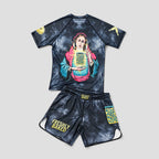 A two-piece unisex athletic set consisting of a short-sleeve rash guard and matching shorts, featuring a dark blue/black mottled tie-dye pattern. The rash guard has a large graphic of a woman holding a playing card on the front, with a yellow playing card patch on the sleeve.