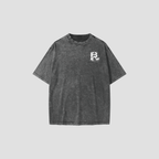 A dark gray acid-wash t-shirt with a small white graphic logo on the left chest, displayed against a solid light gray background.