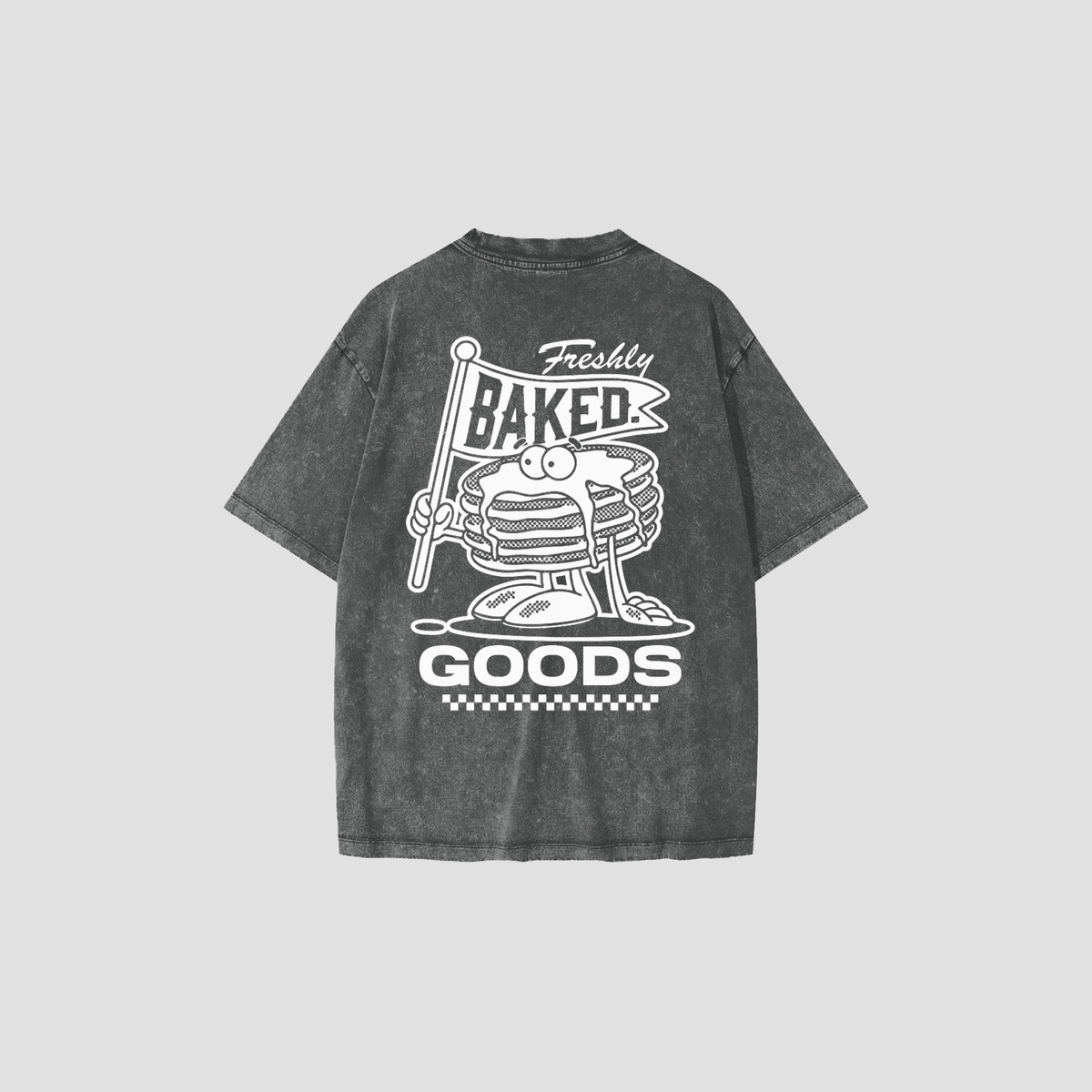 A dark gray acid-wash t-shirt shown from the back, featuring a white graphic print of a stack of pancakes with a flag that reads 'Freshly Baked' and the words 'GOODS' below.