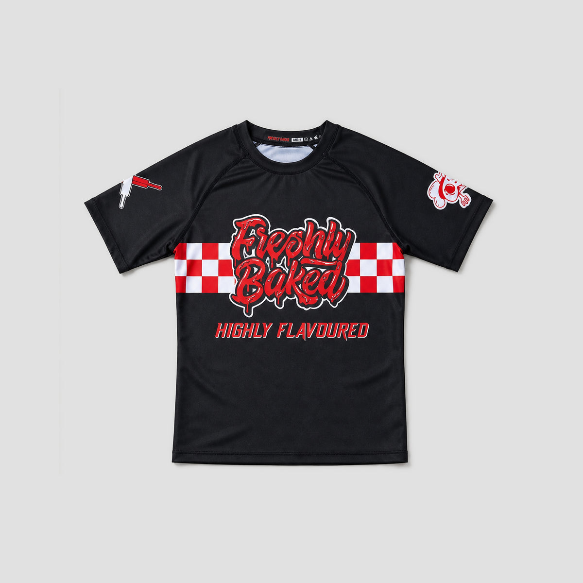 A black short-sleeve athletic t-shirt with a red and white checkered graphic across the chest reading 'Freshly Baked' and 'HIGHLY FLAVOURED' in red. The shirt features a small red and white logo on the right sleeve and a small white graphic on the left sleeve, displayed against a solid light gray background.