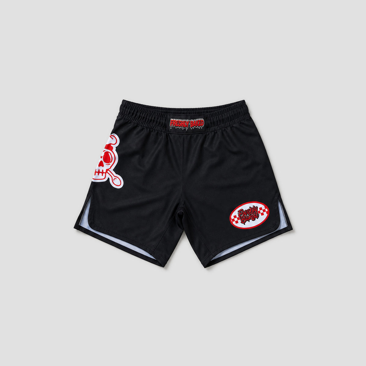 Black athletic shorts with red and white graphics, featuring a skull logo on the left leg and a circular patch on the right leg, displayed against a light gray background.