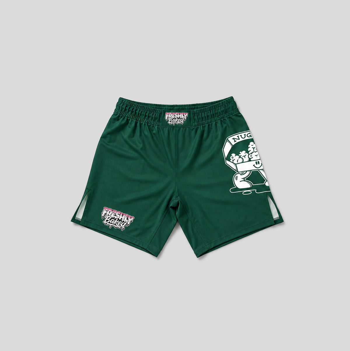 Dark green athletic shorts with white and pink 'FRESHLY BAKED' graphics, including a large mascot graphic on the left leg and a smaller logo on the right leg, shown against a solid gray background.