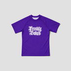 A purple short-sleeve crewneck t-shirt with 'Freshly Baked' printed in a white gothic font on the chest, displayed against a light gray background.