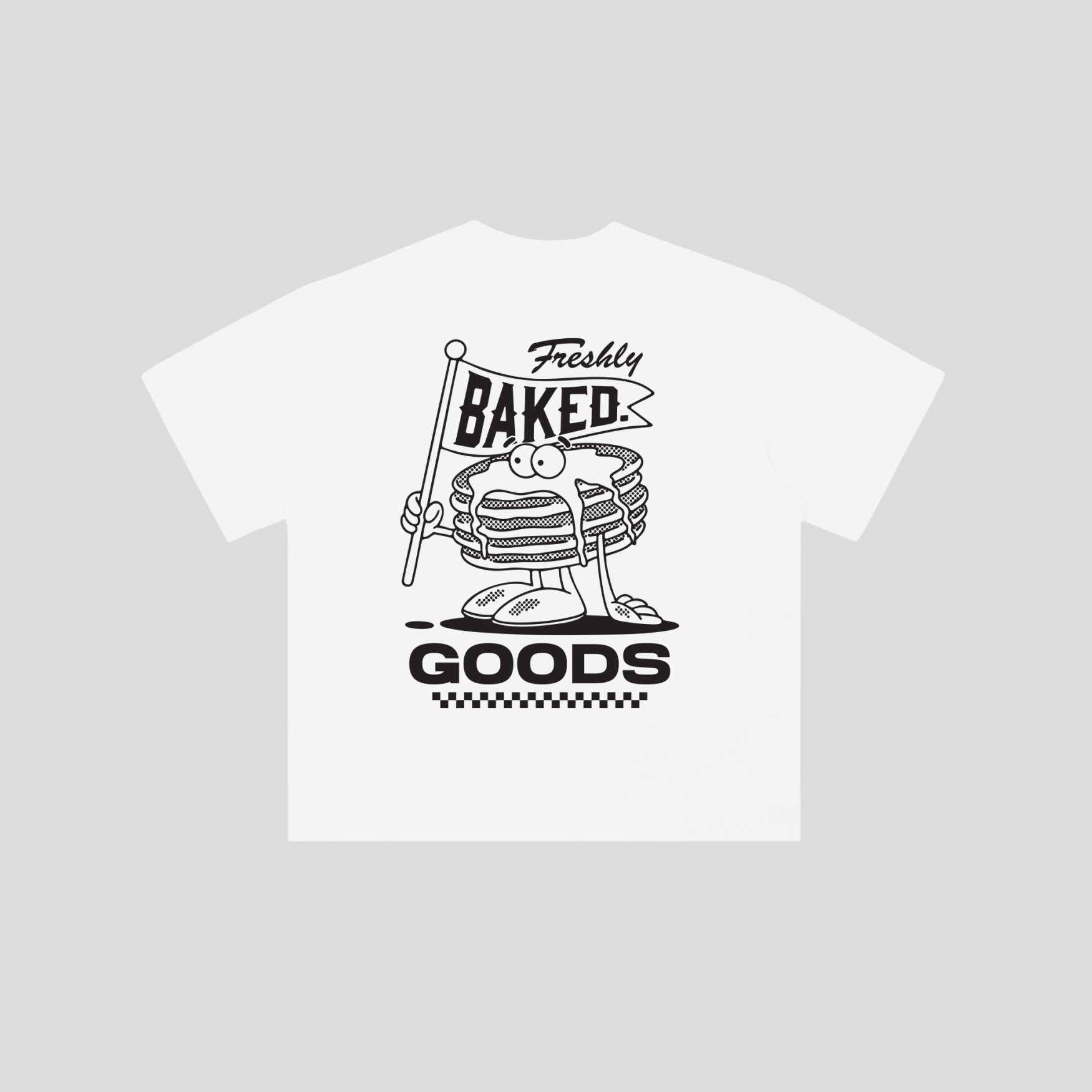 A white short-sleeve t-shirt with a black graphic print of a cartoon stack of pancakes holding a 'Freshly Baked Goods' sign, displayed on a solid light gray background.