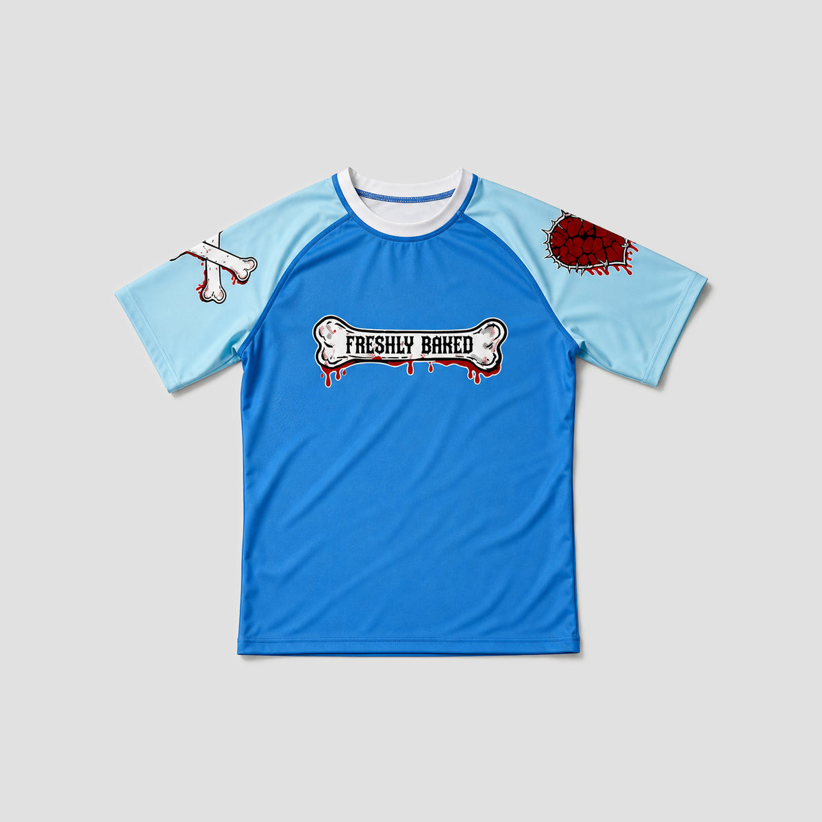 A short-sleeve raglan t-shirt with a bright blue body and light blue sleeves, featuring a 'FRESHLY BAKED' bone graphic on the chest with dripping red details, a blood splatter on the right sleeve, and a bone graphic on the left sleeve, shown on a neutral gray background.
