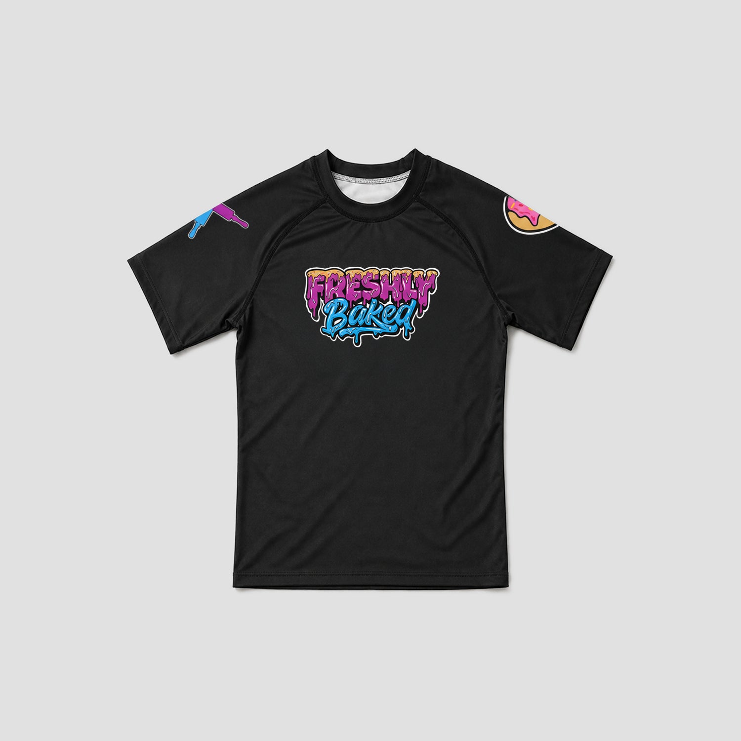 A black short-sleeve athletic t-shirt with a colorful 'Freshly Baked' graphic on the chest, featuring a pink and purple gradient design with blue shadowing. The shirt also has a small purple graphic on the right sleeve and a donut graphic on the left sleeve, shown against a solid light gray background.