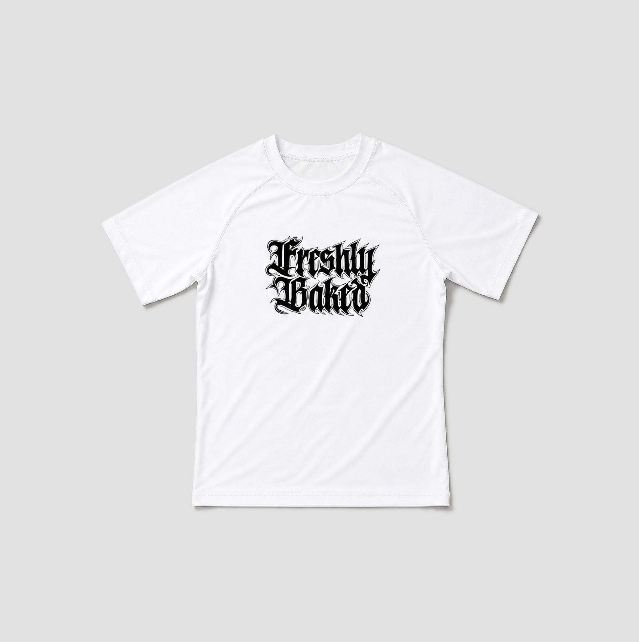 A white short-sleeve t-shirt with a black gothic-style 'Freshly Baked' graphic printed on the chest, displayed against a solid light gray background.