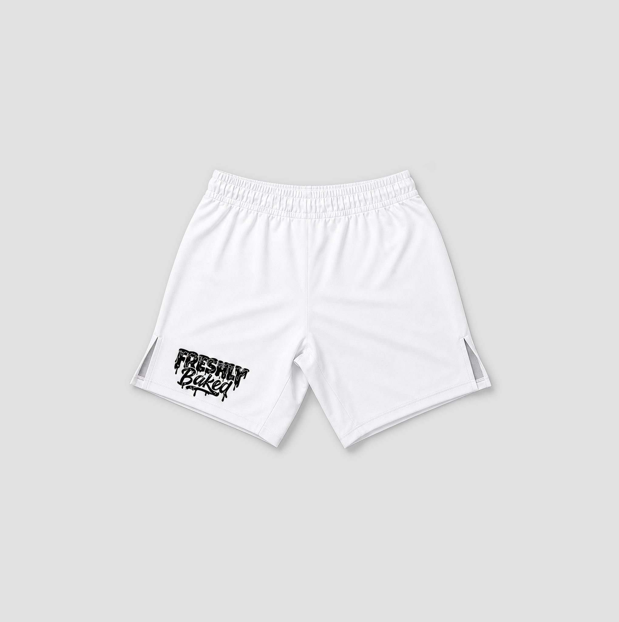 White athletic shorts with an elastic waistband, featuring a black distressed 'FRESHLY BAKED' graphic on the lower left leg and side cutout details, shown against a light gray background.