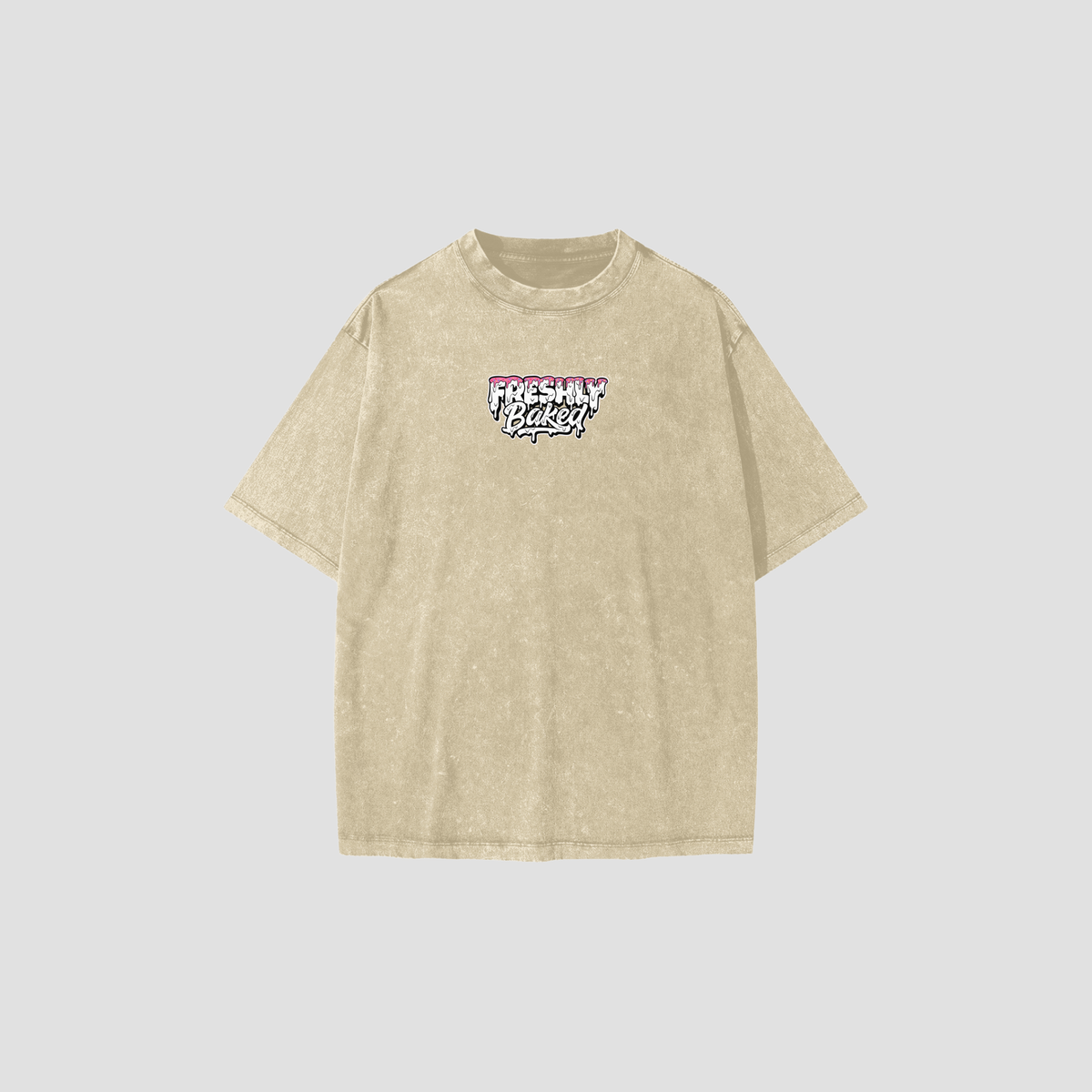 A light beige acid-wash t-shirt with a 'Freshly Baked' graphic on the chest, displayed against a solid light gray background.