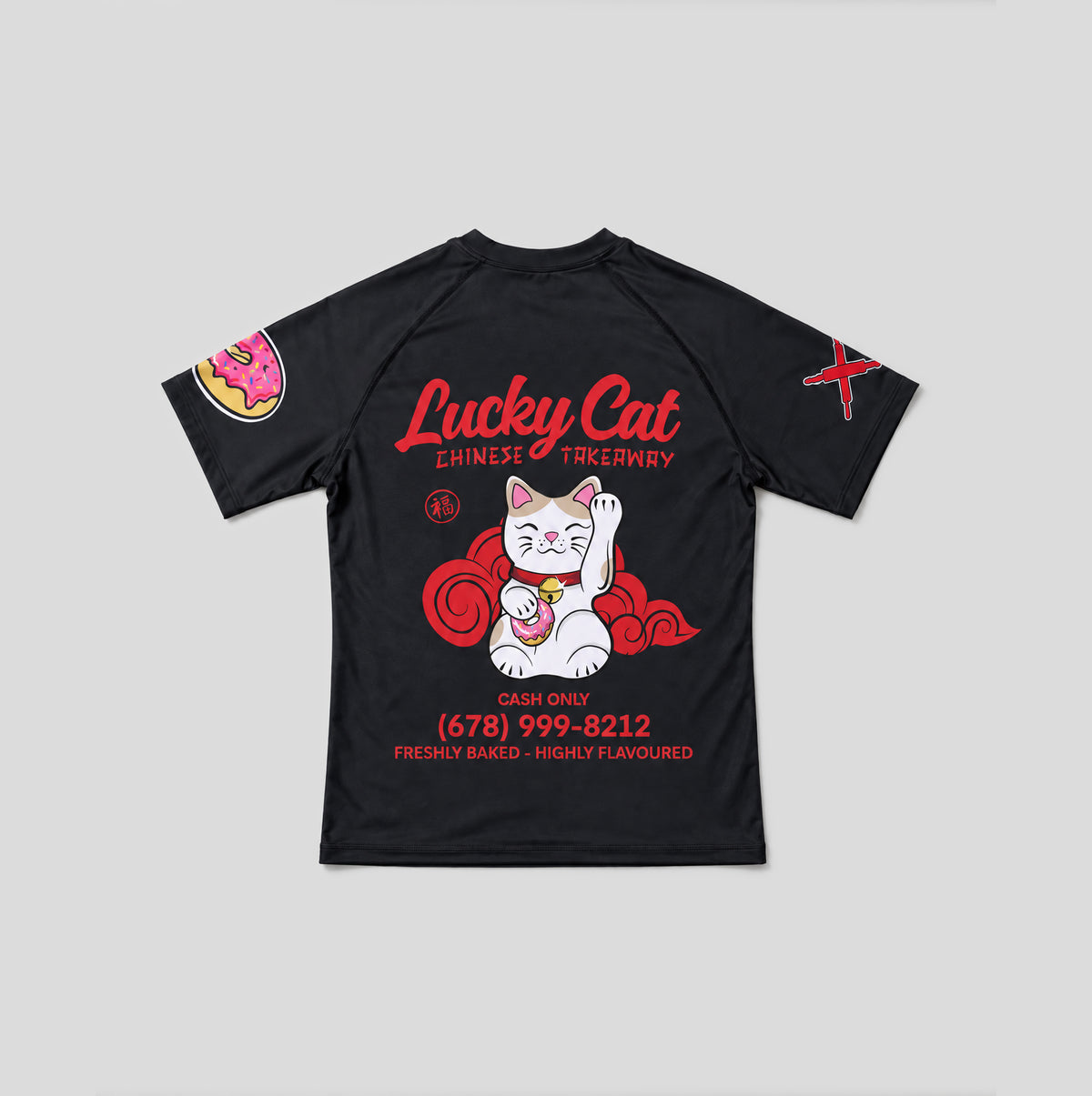 A black short-sleeve t-shirt with a large graphic on the back featuring a white and red lucky cat, red text reading 'Lucky Cat Chinese Tackyary', and a pink donut graphic on the left sleeve, shown on a light gray background.