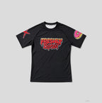 A black short-sleeve athletic t-shirt with a colorful 'Freshly Baked!' graphic on the chest, a red graphic on the right sleeve, and a pink donut graphic on the left sleeve, shown on a neutral gray background.