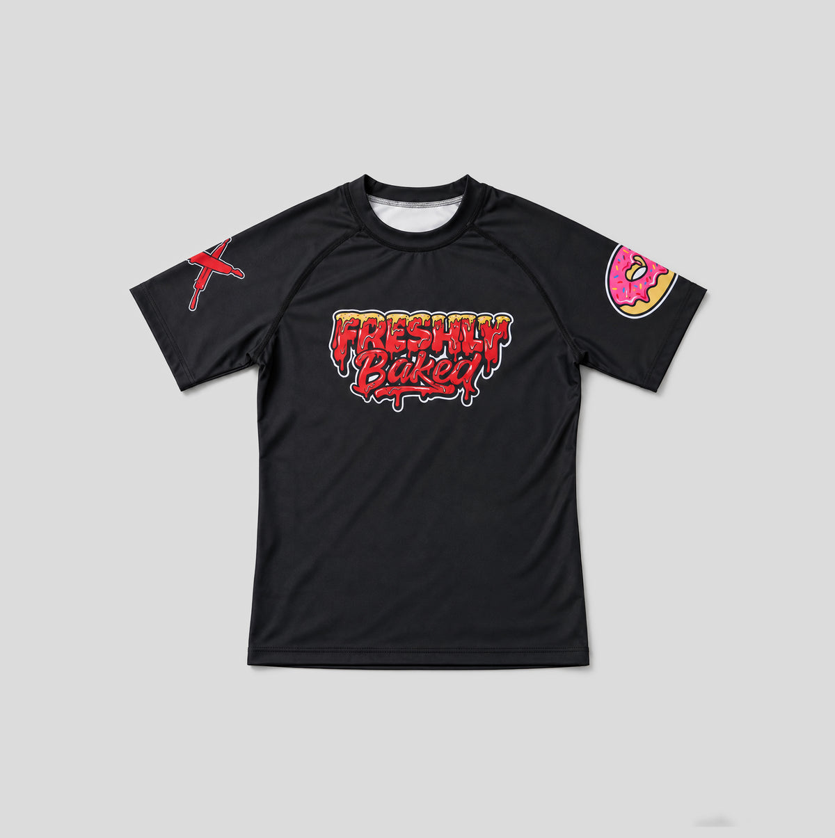 A black short-sleeve athletic t-shirt with a colorful 'Freshly Baked!' graphic on the chest, a red graphic on the right sleeve, and a pink donut graphic on the left sleeve, shown on a neutral gray background.